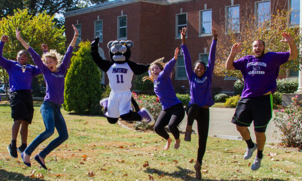 Students and KWC mascot leaping into the air