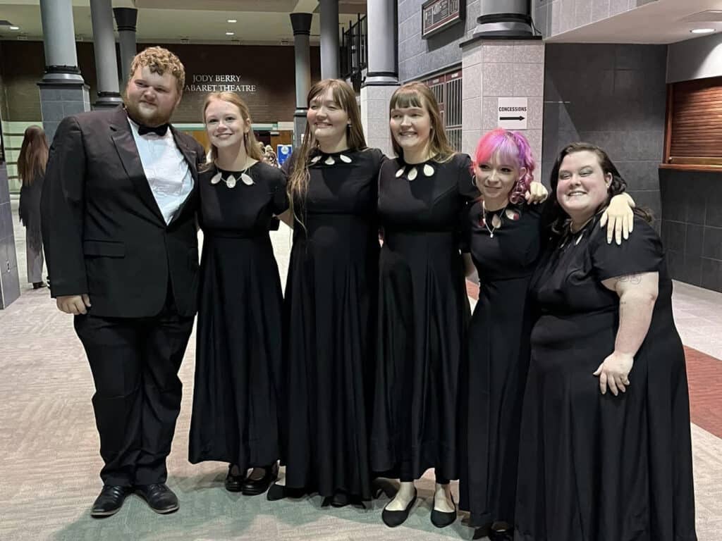Six members of the Kentucky Wesleyan Singers pose with smiling faces after a performance