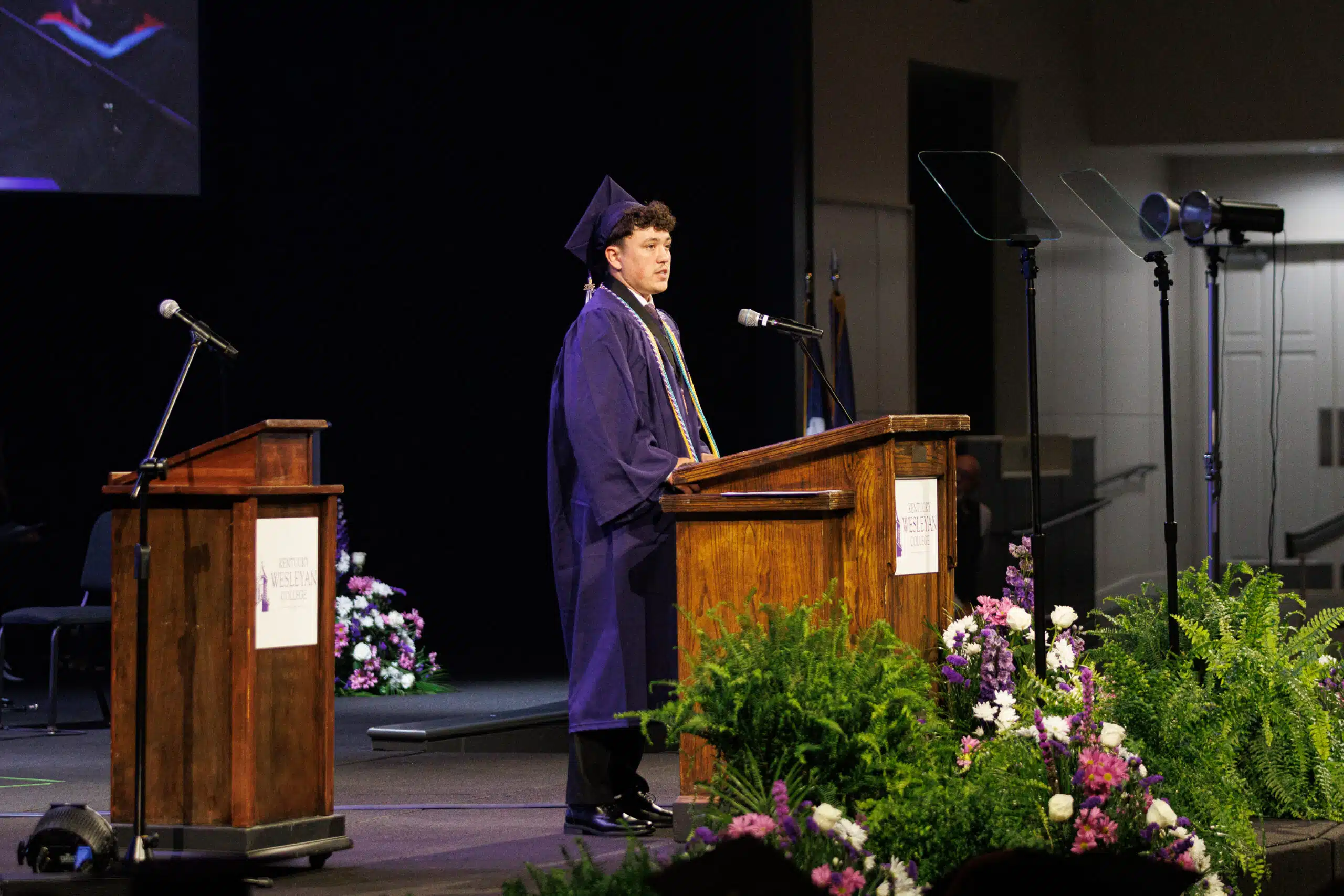 Valedictorian delivering commencement address at podium.