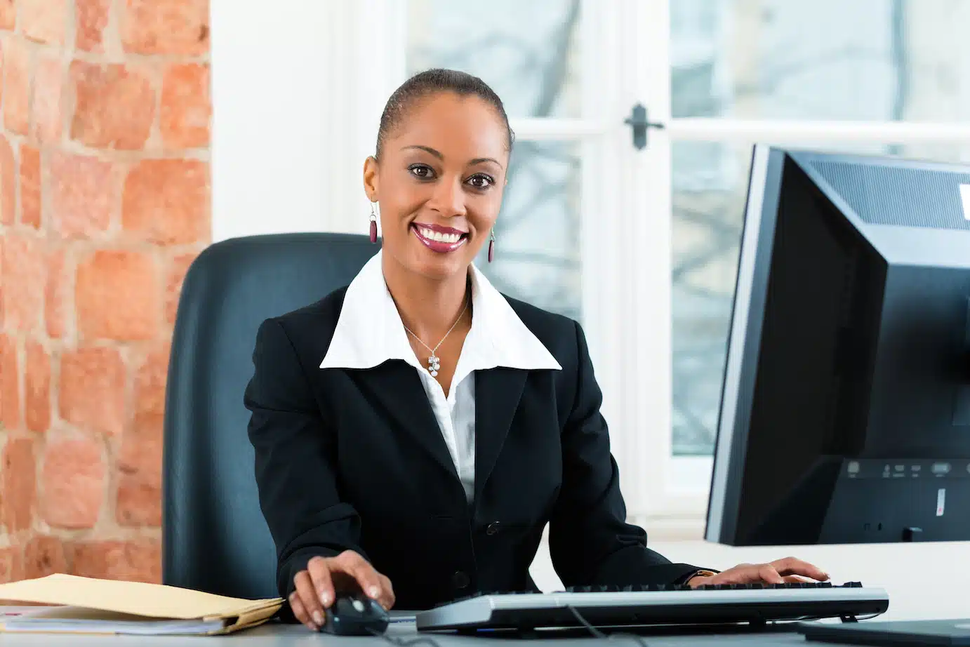Young female lawyer or paralegal working in her office on a computer