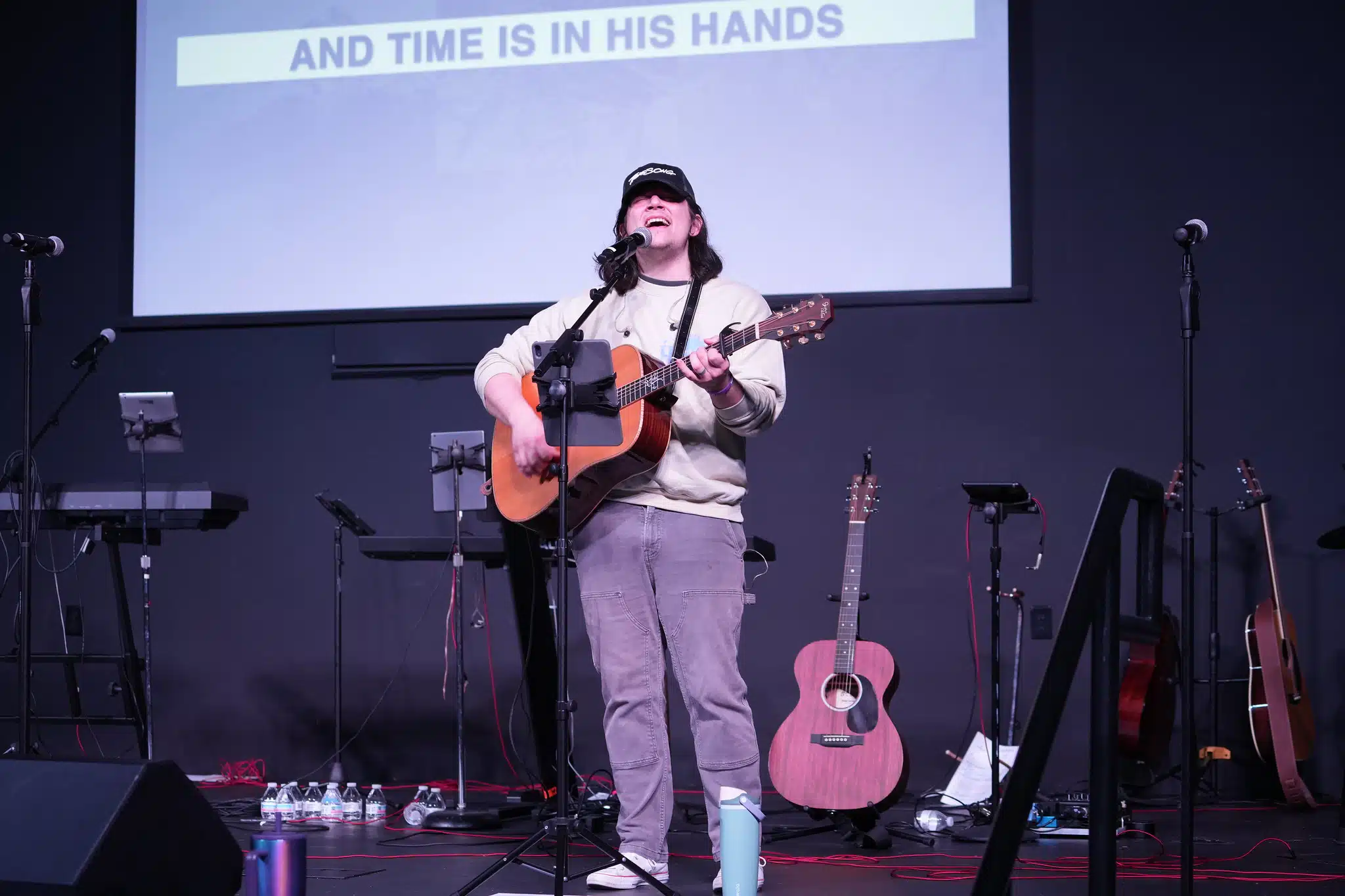 Student with guitar leading on stage