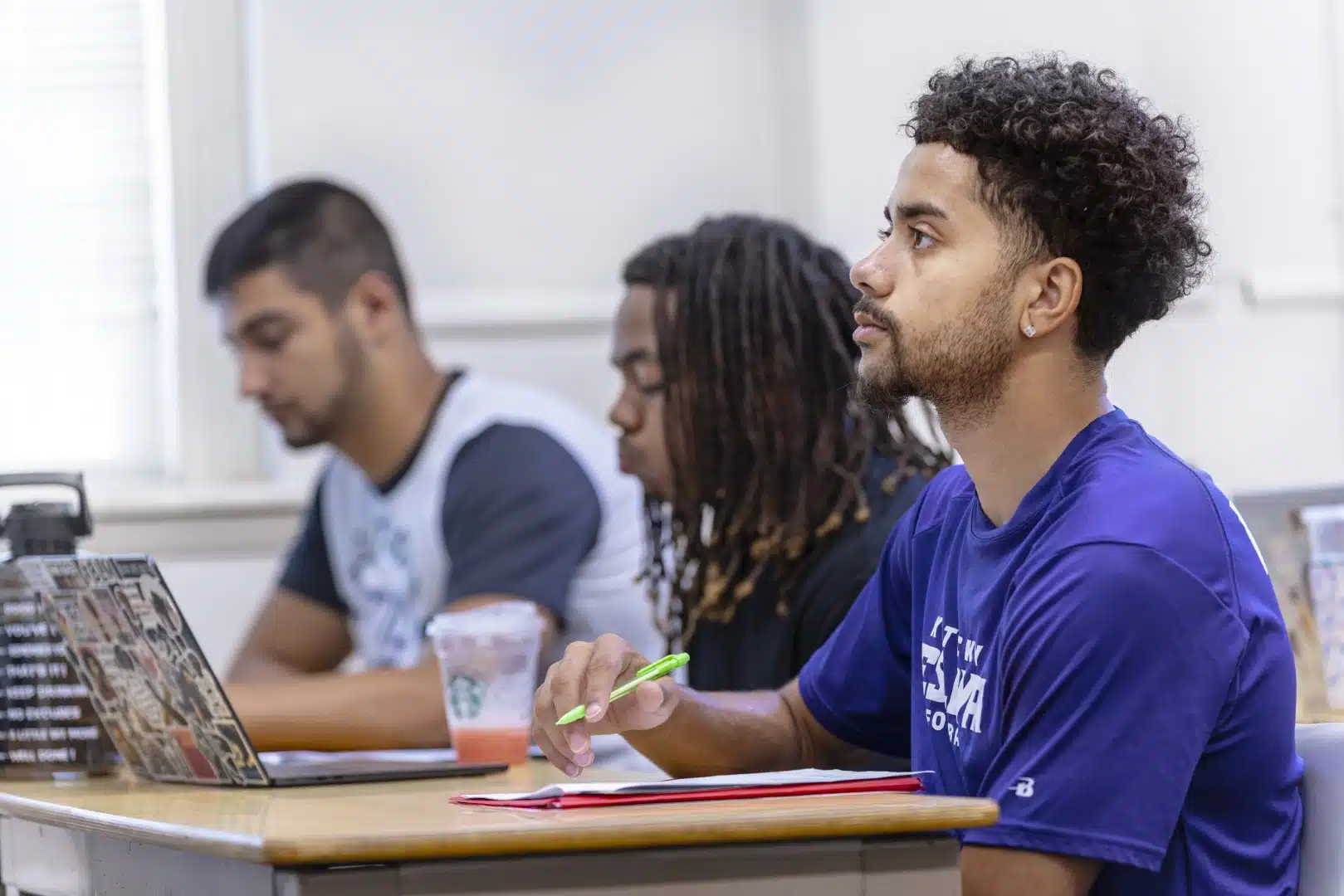 A student engaging with the lecture inside a KWC classroom