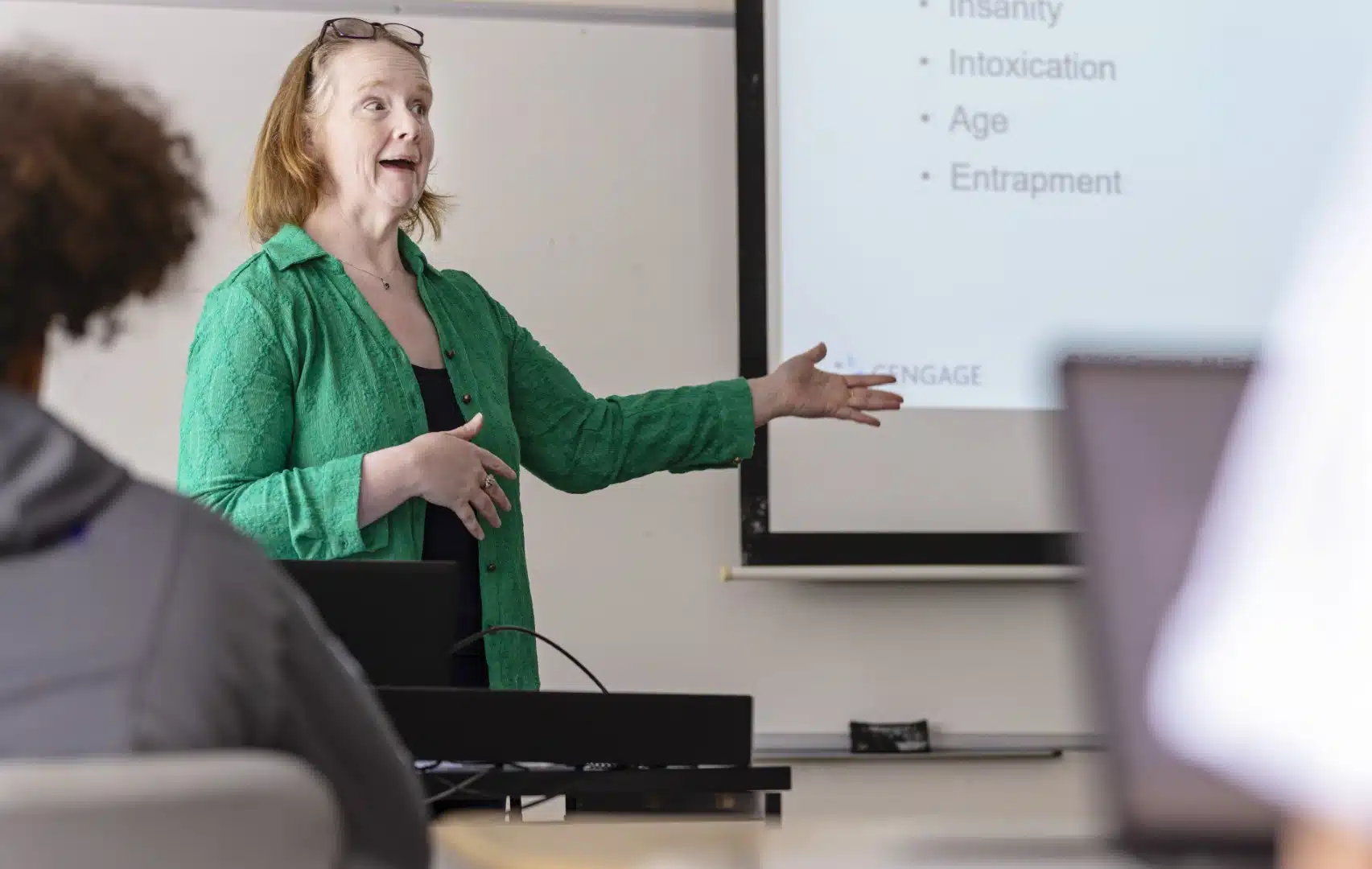 A professor presents at the front of the classroom