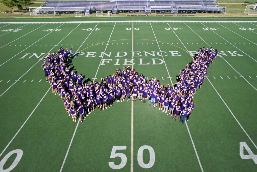 Incoming Kentucky Wesleyan students standing in a W-shaped formation on a football field