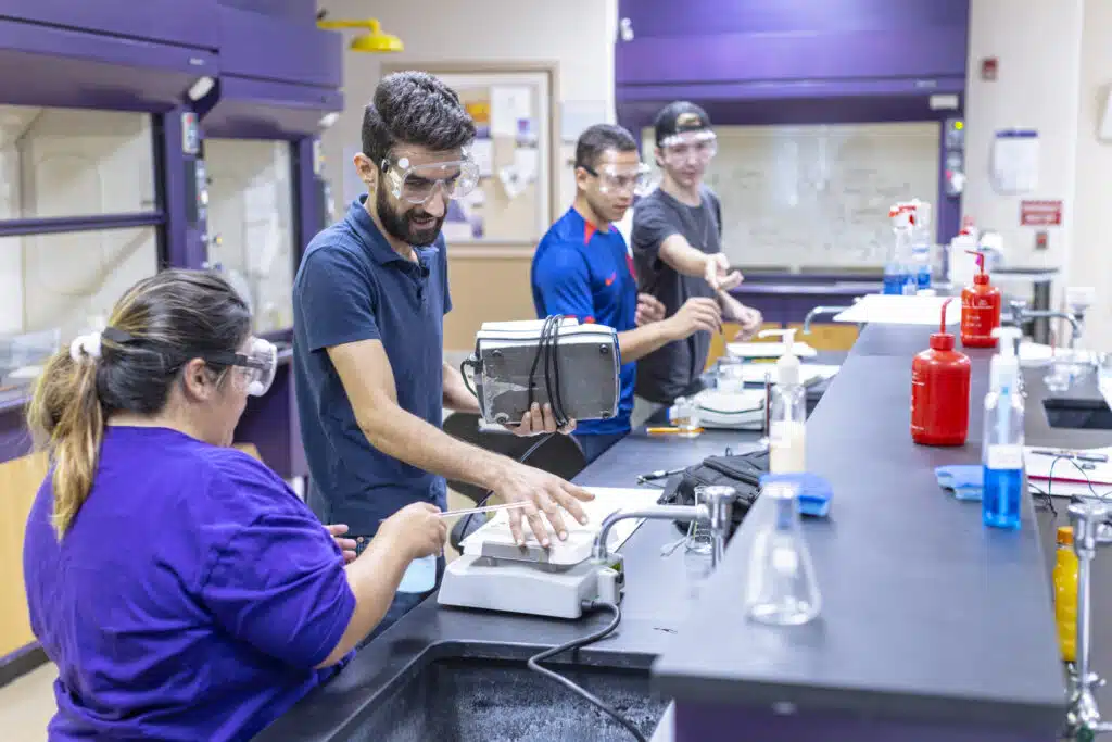A group of KWC lab students working with a hands-on activity inside a science/chemistry lab