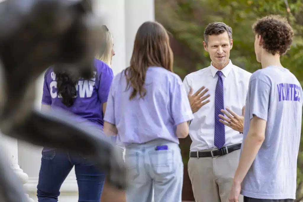 A group of students listening to Dr. Cousins speak outside
