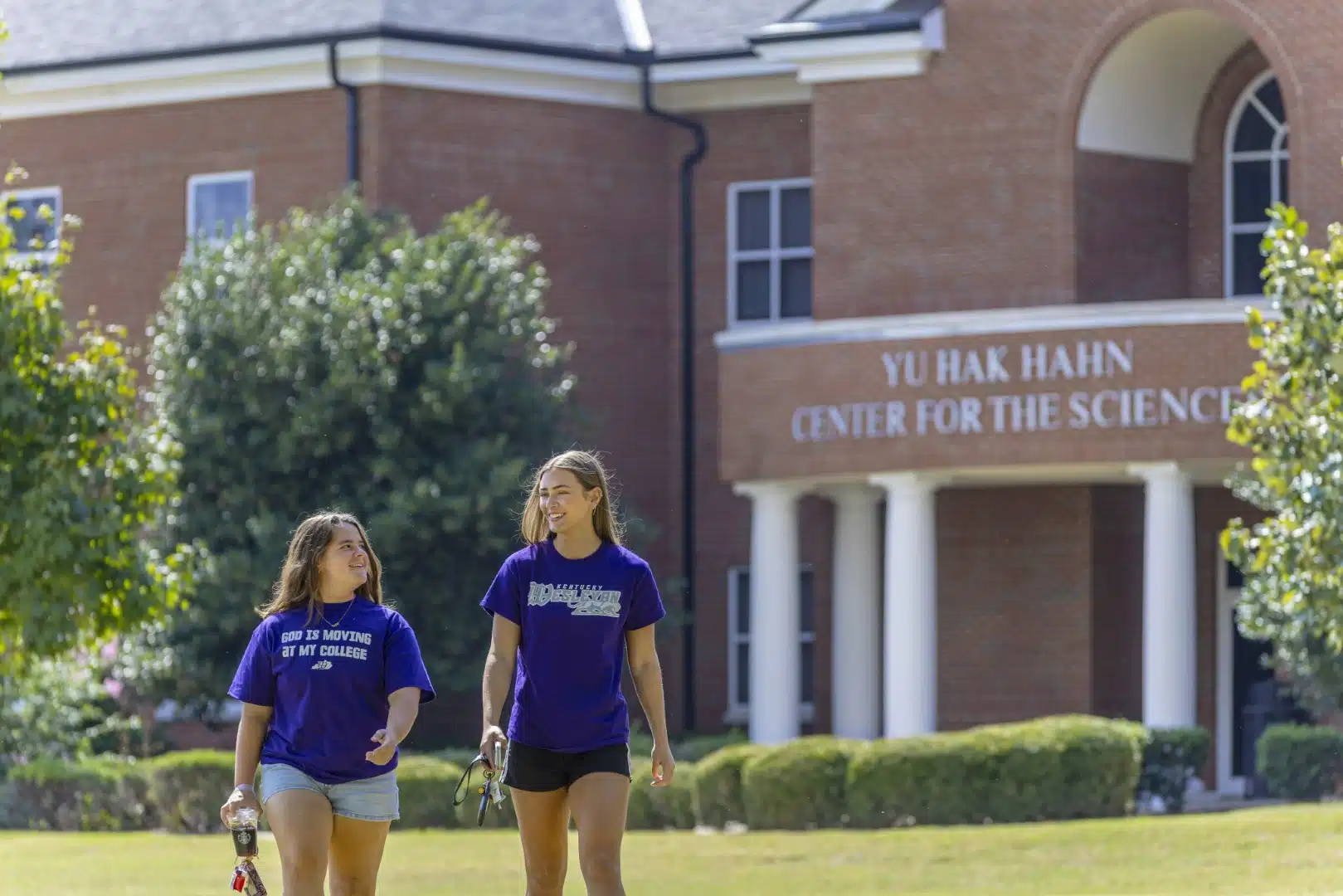 Two students walk outside the science building on campus