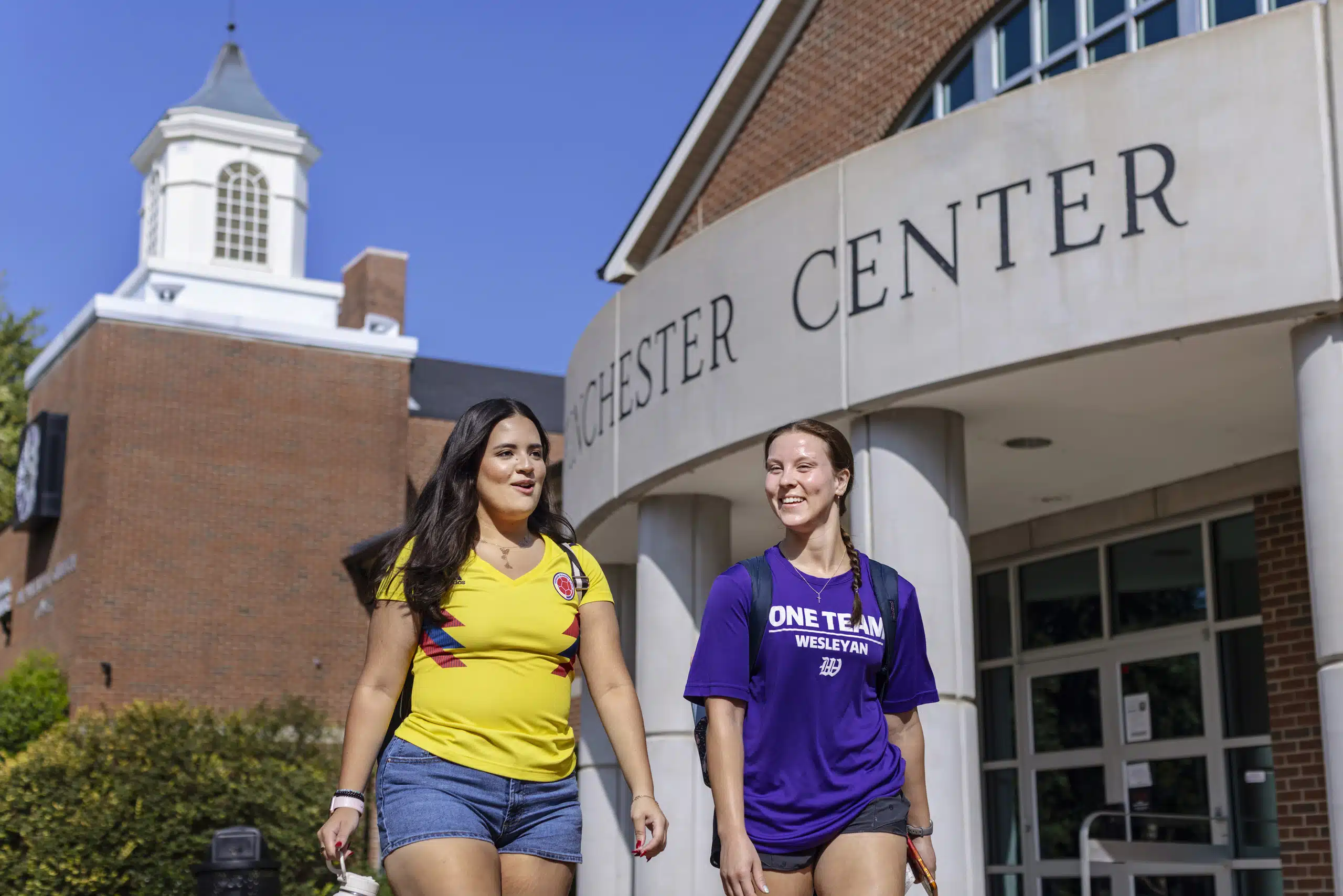 Two students walking outside the Winchester Center on campus