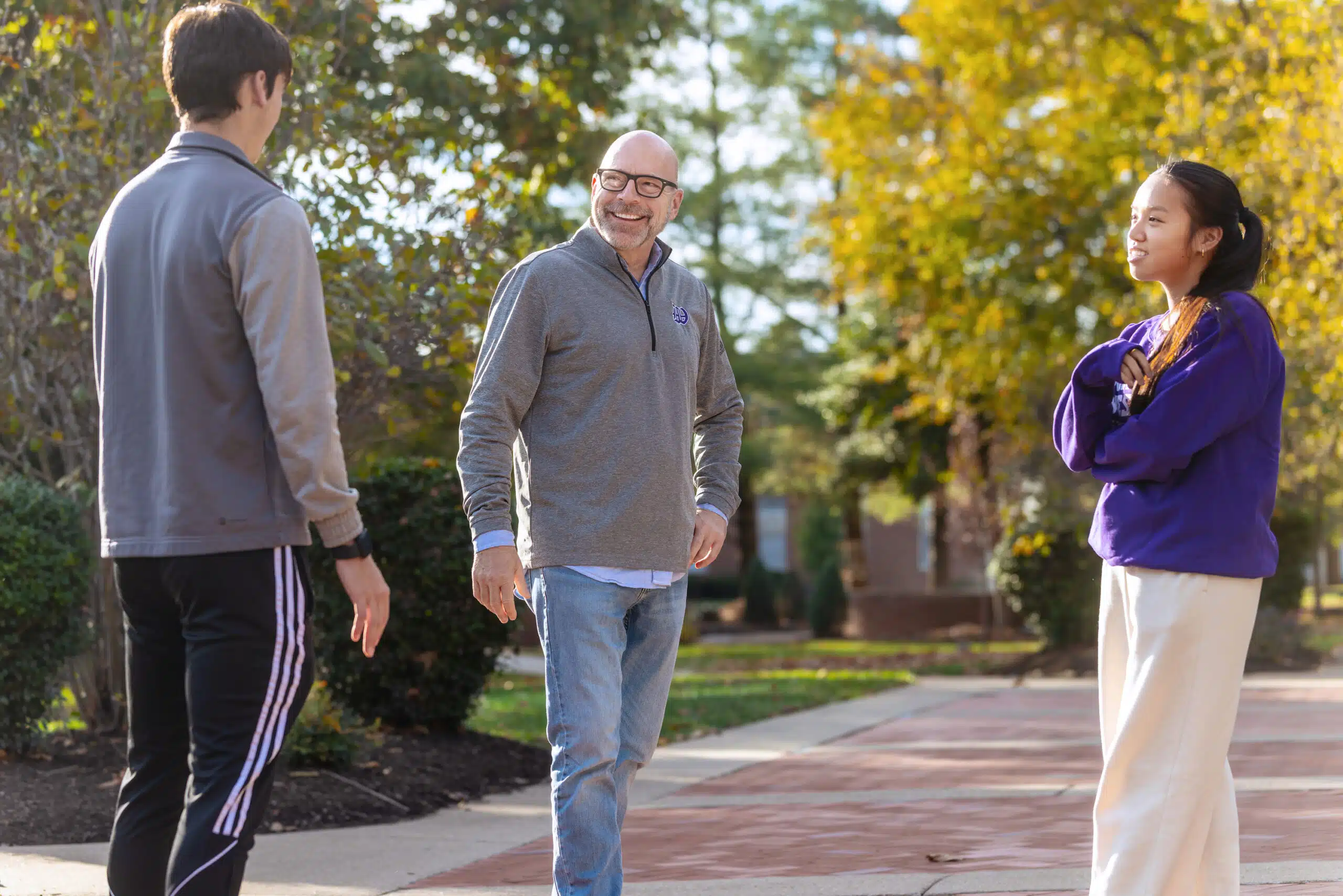 Professor talking to two students outside Winchester