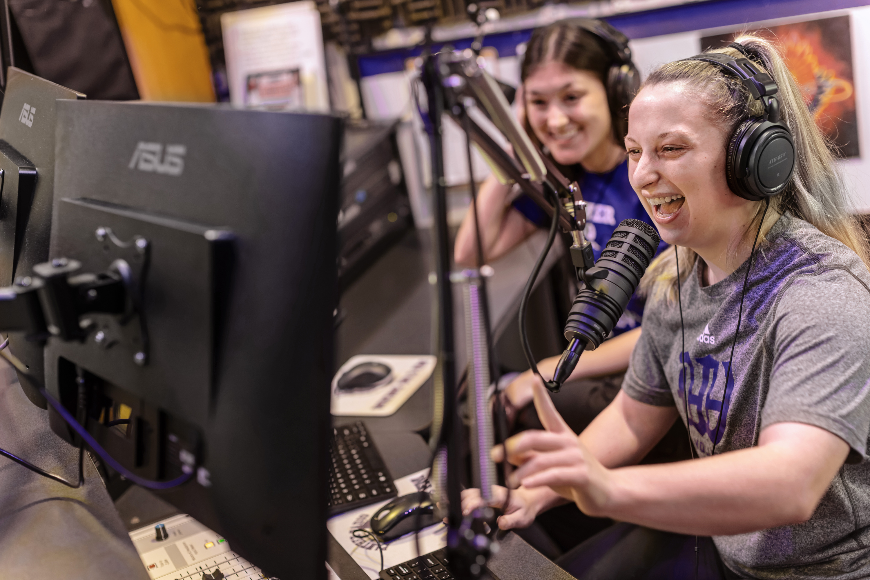 Students smiling and working in the radio studio