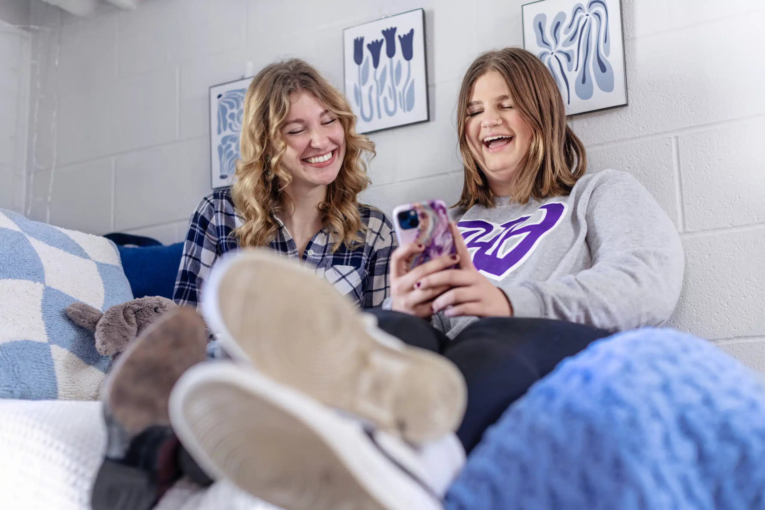 Two students laughing together in a residence hall