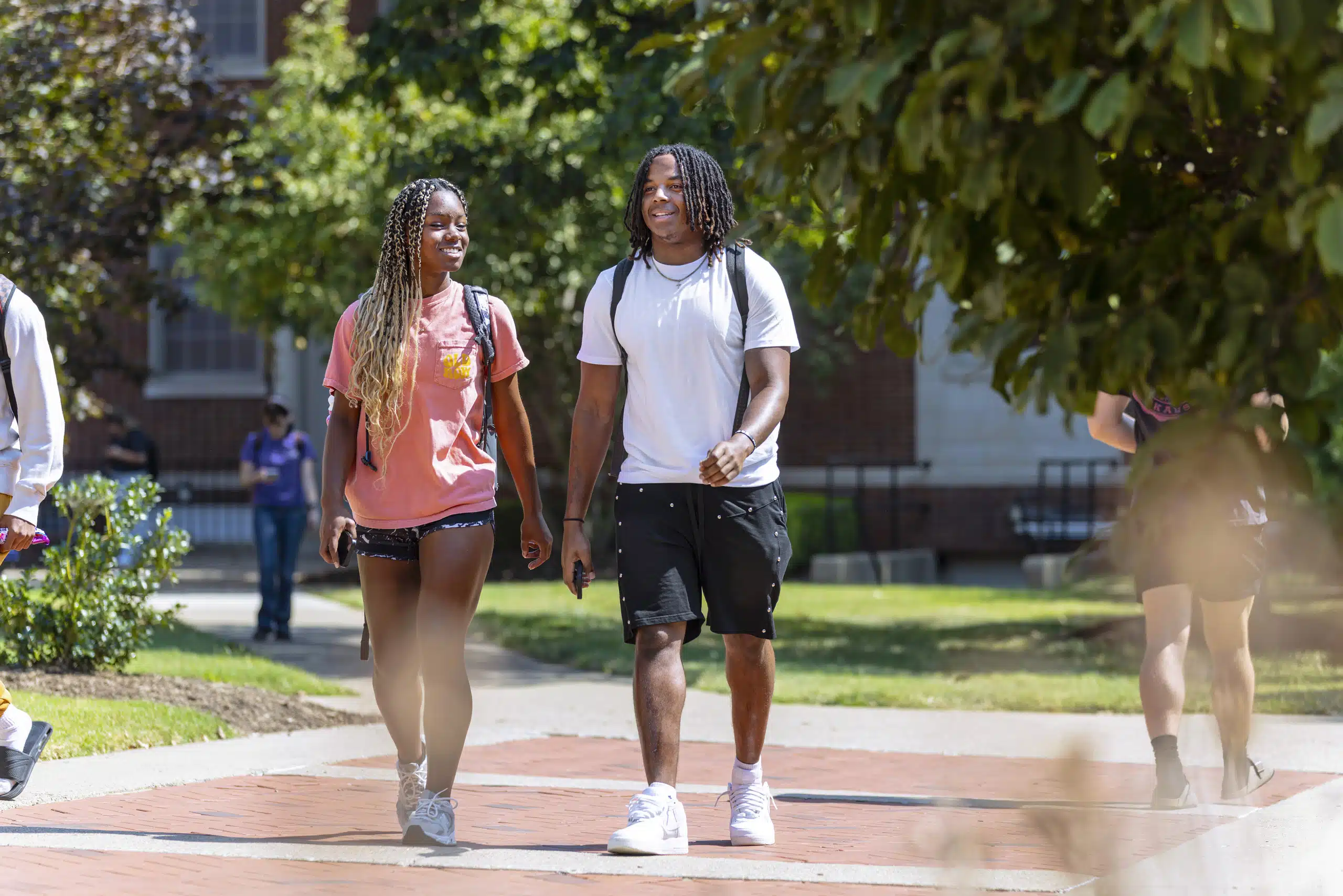 Students walking outside on paved pathways on campus