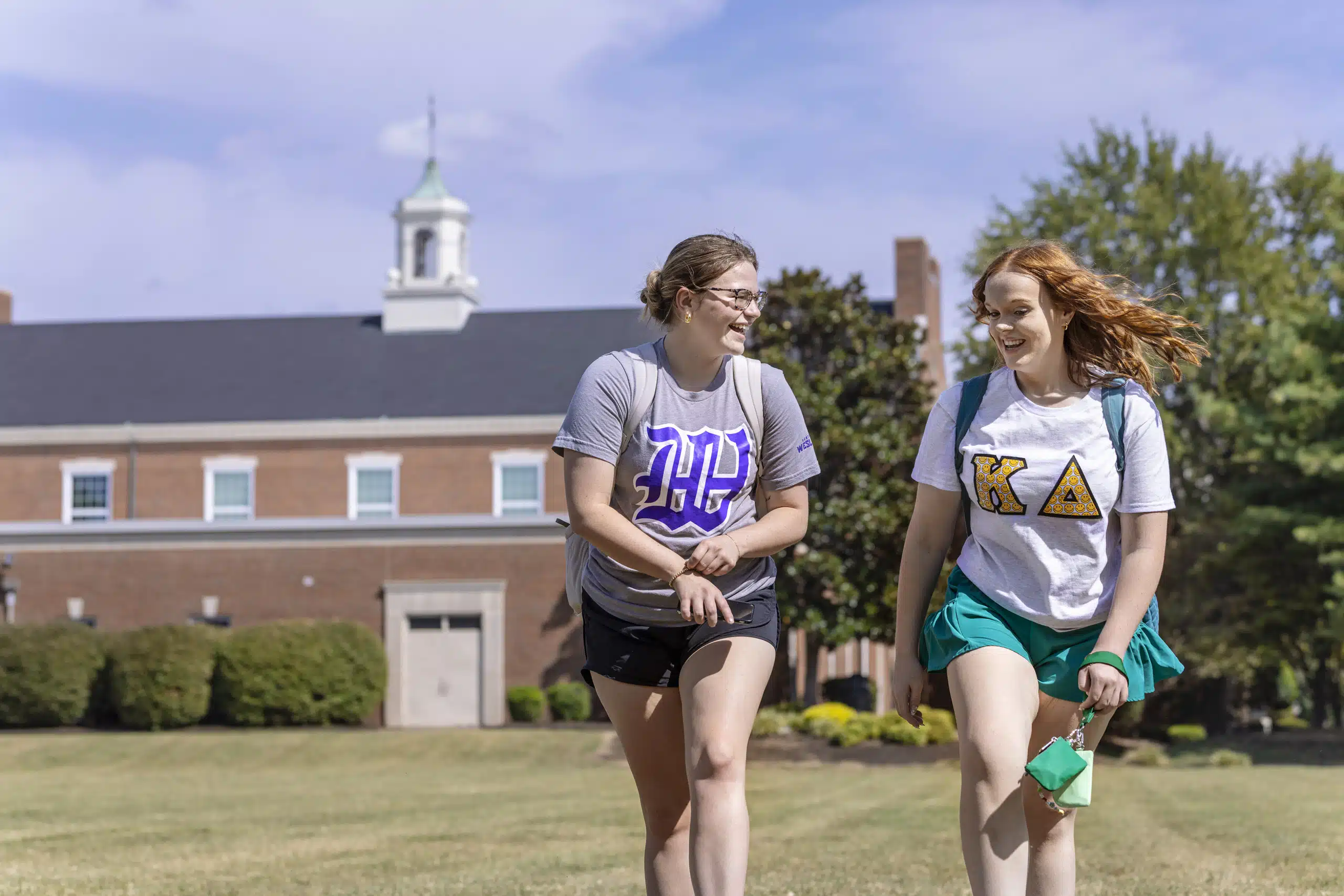 Two students talking and walking outside the residence halls on campus