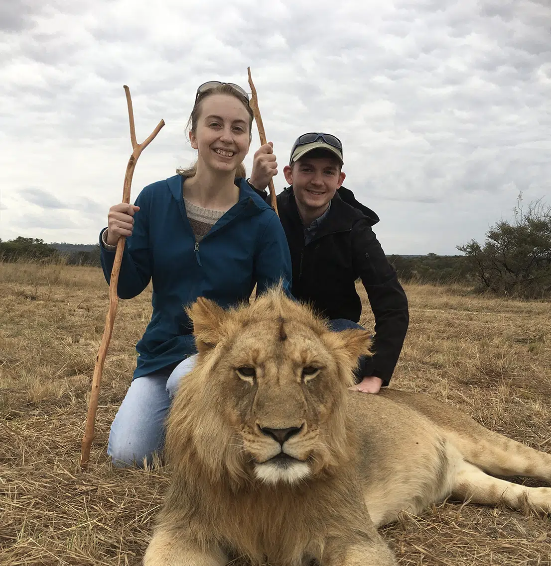 Two students pose with lion in Zimbabwe